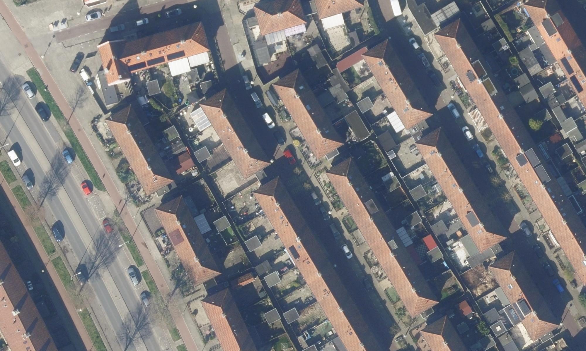 Luchtfoto van rijtjeshuizen in Amsterdam-Noord, met één dak gemarkeerd